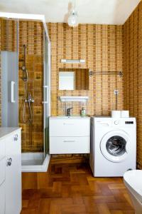 uma casa de banho com uma máquina de lavar roupa e um chuveiro em La Sirène, à 250 m de la plage, T2 lumineux avec une terrasse spacieuse de15m² em Saint-Cyprien