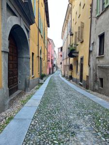 an empty street in an alley between buildings at Maison des Artistes in Pinerolo