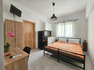 Un dormitorio con una cama y un escritorio en una habitación. en Exarhos Apartment, en Paralia Katerinis