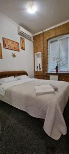 1 dormitorio con 1 cama grande con sábanas blancas y ventana en Софиевская 8, en Kiev