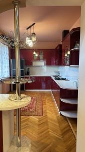 cocina con armarios rojos y suelo de madera en Nice House, en Ijevan