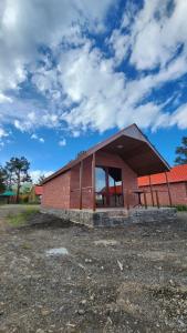 un edificio de ladrillo rojo con un banco delante de él en Sevan - Lavanda Cottages, en Sevan