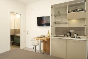 a kitchen with white cabinets and a wooden table at Studio apartment in the Castle Castelsardo in Castelsardo +48 photos