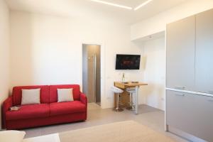a living room with a red couch and a desk at Studio apartment in the Castle Castelsardo in Castelsardo