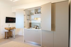 a kitchen with white cabinets and a desk at Studio apartment in the Castle Castelsardo in Castelsardo