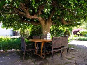 a wooden table and chairs under a tree at Rosalie Cottage in Beaurepaire