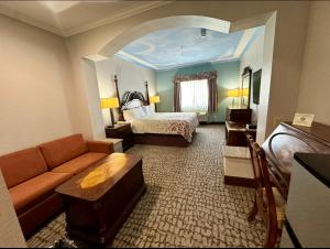 um grande quarto de hotel com uma cama e um sofá em Crystal Suites em Texas City