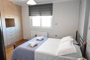 sypialnia z łóżkiem z białą pościelą i oknem w obiekcie Vasiliki’s Guesthouse w Atenach