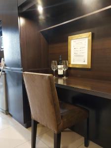 a bar with a bottle of wine and a chair at Comfortable Modern Apartment in Buenos Aires
