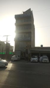 un edificio con coches estacionados frente a él en Hotline Apartments, en Lahore