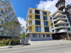 a yellow and white apartment building next to a street at Apartament RAMI Mamaia Nord in Mamaia Nord