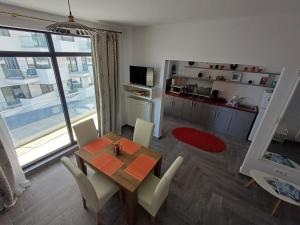 a dining room with a table and chairs and a kitchen at Apartament RAMI Mamaia Nord in Mamaia Sat/Năvodari
