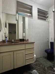 uma casa de banho com um lavatório, um WC e um espelho. em LGBT Friendly - Quarto em Ipanema Posto 9 - Casa de Vitor e Carlos no Rio de Janeiro