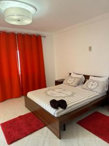 a bedroom with a bed with red curtains and red rugs at Superbe Villa Face à l'Ocean - Agadir beach City in Agadir