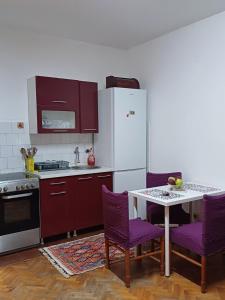 a kitchen with purple chairs and a white refrigerator at Summer Vibes Apartment in Karaburma