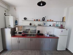 a kitchen with white appliances and a red counter top at Apartament RAMI Mamaia Nord in Mamaia Sat/Năvodari