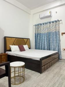 een slaapkamer met een bed en een stoel bij Shri Ram International Home Stay Ayodhya in Ayodhya