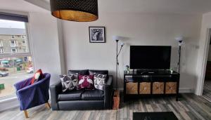 a living room with a couch and a television at The Penthouse NY Loft Apartment in Barmouth
