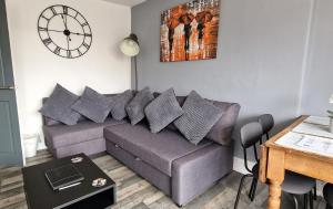 a living room with a couch and a clock on the wall at The Penthouse NY Loft Apartment in Barmouth