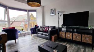 a living room with a couch and a flat screen tv at The Penthouse NY Loft Apartment in Barmouth