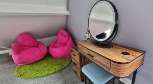 a mirror and two pink bean bags in a room at The Penthouse NY Loft Apartment in Barmouth