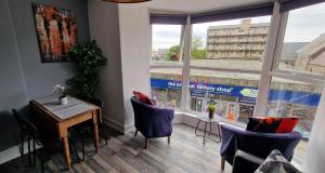 a room with a table and chairs and a window at The Penthouse NY Loft Apartment in Barmouth