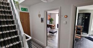 a hallway with a stairway leading to a living room at The Penthouse NY Loft Apartment in Barmouth