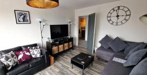 a living room with a couch and a tv at The Penthouse NY Loft Apartment in Barmouth