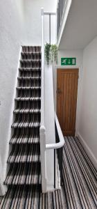 a staircase with a black and white striped carpet at The Penthouse NY Loft Apartment in Barmouth
