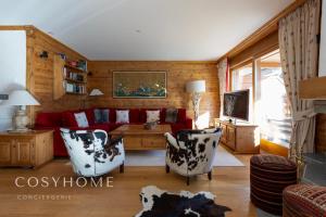uma sala de estar com um sofá vermelho e cadeiras em Le Saint Georges l Jardin et vue em Crans-Montana