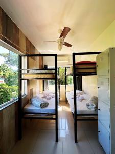two bunk beds in a room with a ceiling fan at Mata Virgem Hostel e Pousada in Abraão +22 photos