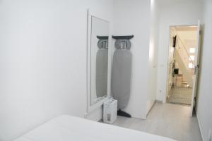 Baño blanco con espejo y escalera en Dina Beach house, en Nazaré