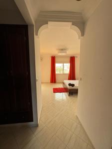 Zimmer mit einem Bett und einem Fenster mit roten Vorhängen in der Unterkunft Superbe Villa Face à l'Ocean - Agadir beach City in Agadir