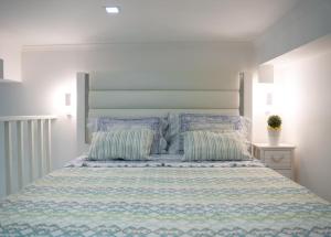 1 dormitorio con 1 cama con edredón azul y blanco en Dina Beach house, en Nazaré