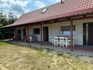 a house with a porch with a table and chairs at U Zgagi in Mikoszewo
