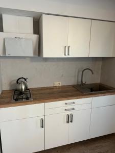 a kitchen with white cabinets and a sink at U Zgagi in Mikoszewo