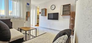 - un salon avec un canapé et une horloge murale dans l'établissement Apartment Vlado, à Vrsar