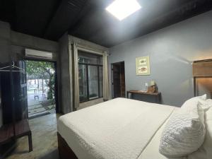 a bedroom with a white bed and a window at San Carlos Surf Resort & Eco Lodge in San Carlos