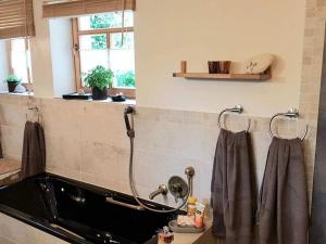 a bathroom with a bath tub with a shower at Appealing apartment in Wilhelmsthal in Wilhelmsthal