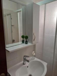 a white bathroom with a sink and a mirror at SUNFLOWER APARTMENT in Dumlupınar +18 photos