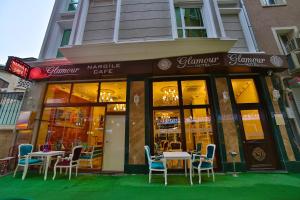 Glamour Hotel Istanbul Sirkeci في إسطنبول: مطعم فيه طاولات وكراسي امام مبنى
