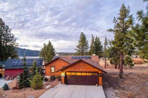 a wooden house with a garage in a field at Lake Time Villa NEW Luxury with HOT TUB in Big Bear Lake
