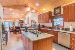 a large kitchen with wooden cabinets and a dining room at Lake Time Villa NEW Luxury with HOT TUB in Big Bear Lake