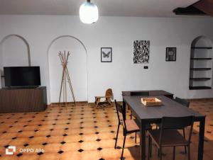 uma sala de jantar com uma mesa e cadeiras e uma televisão em Al focolare di Enzo em Marino