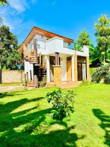 a house with a green lawn in front of it at Golden hour tiny house in Arusha