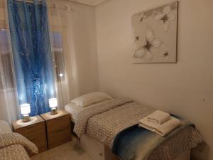 een kleine slaapkamer met een bed en een raam bij Apartamento Playa Flamenca in Orihuela