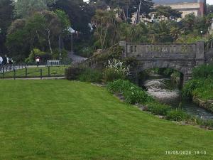 a stone bridge over a river with a grass field at Blue Palms in Bournemouth