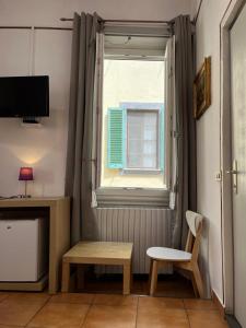 a room with a window and a table and a chair at Althea Rooms in Florence