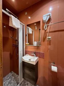 y baño con lavabo y espejo. en Althea Rooms, en Florencia