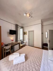 a bedroom with a large bed and a desk at Althea Rooms in Florence